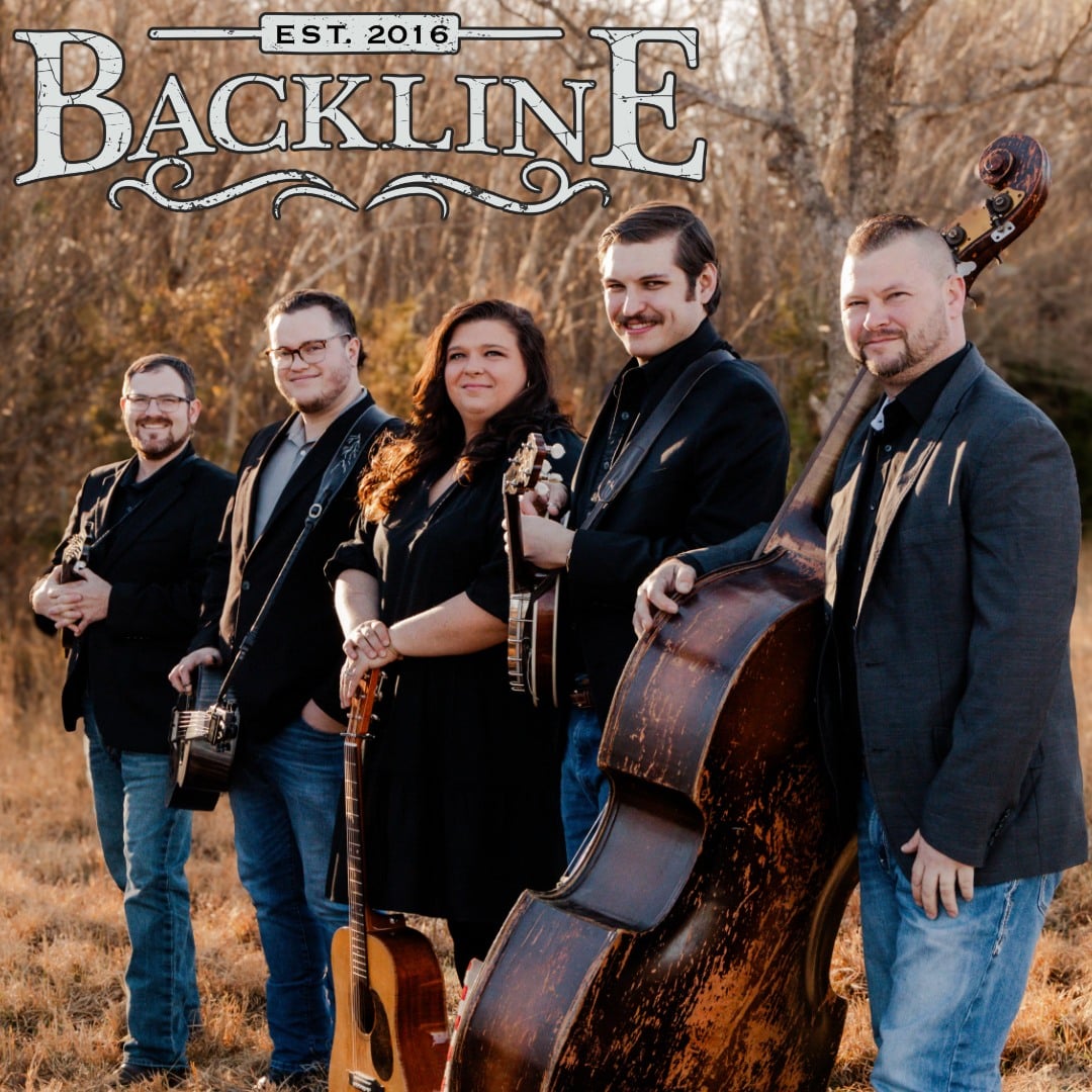 The five members of the band Backline stand together outside, featuring Katelyn Ingardia with her guitar, Travis Tucker with his dobro, Milom Williams II with his mandolin, Zachary Carter with his banjo, and Jason Belue with his upright doghouse bass.