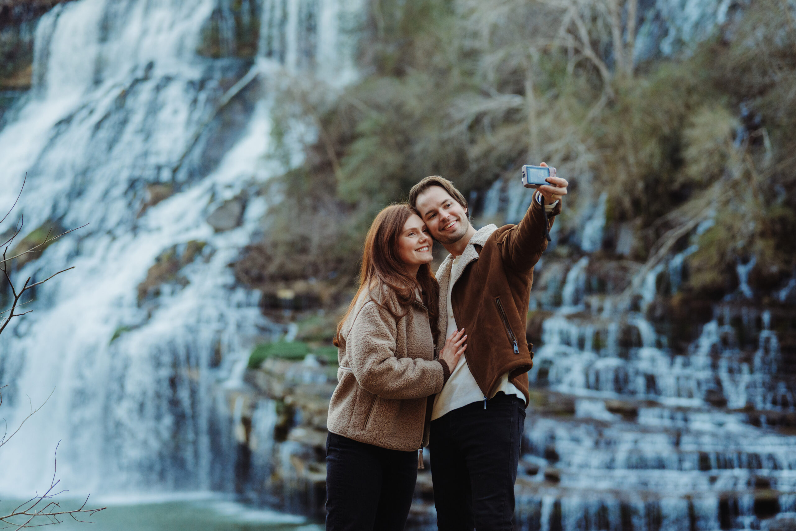 A couple taking a selfie with the cascading white water of Twin Falls at Rock Island State Park near McMinnville, TN.