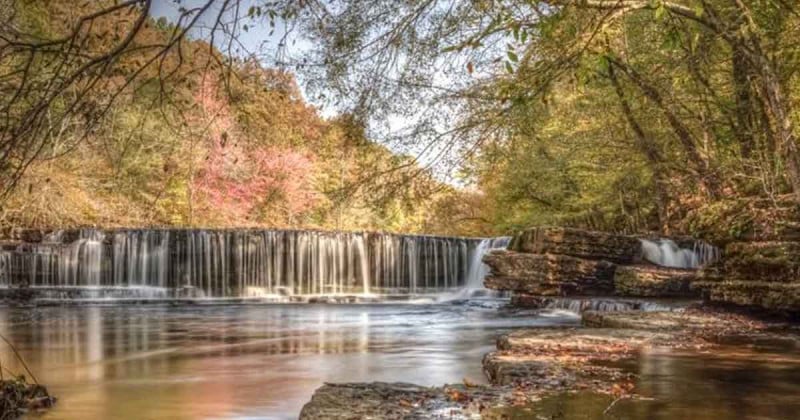 A series of step-down waterfalls flowing over flat rock ledges at Old Stone Fort State Park.