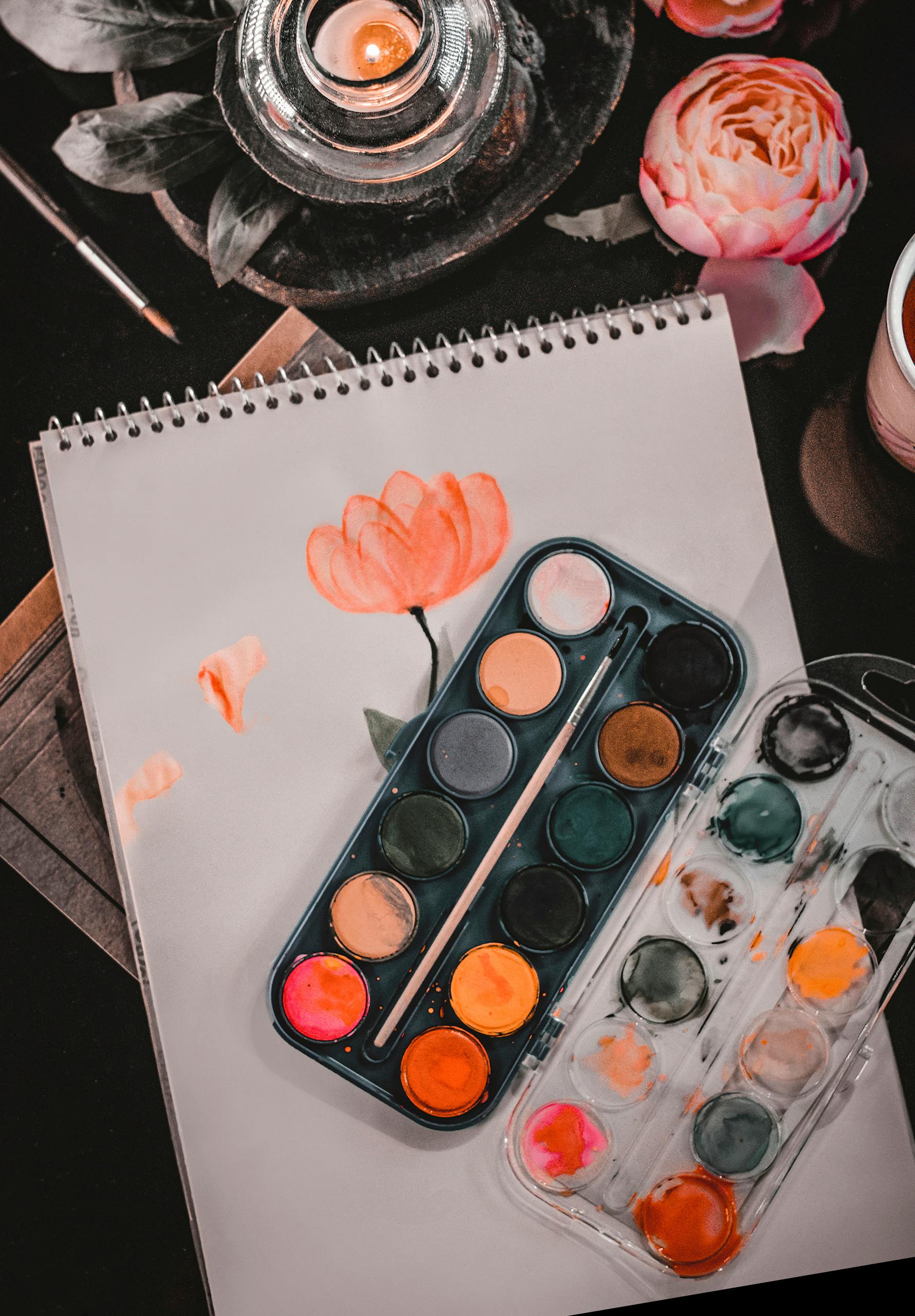 A vibrant watercolor painting of a flower with paint palette and candle in Tehran.